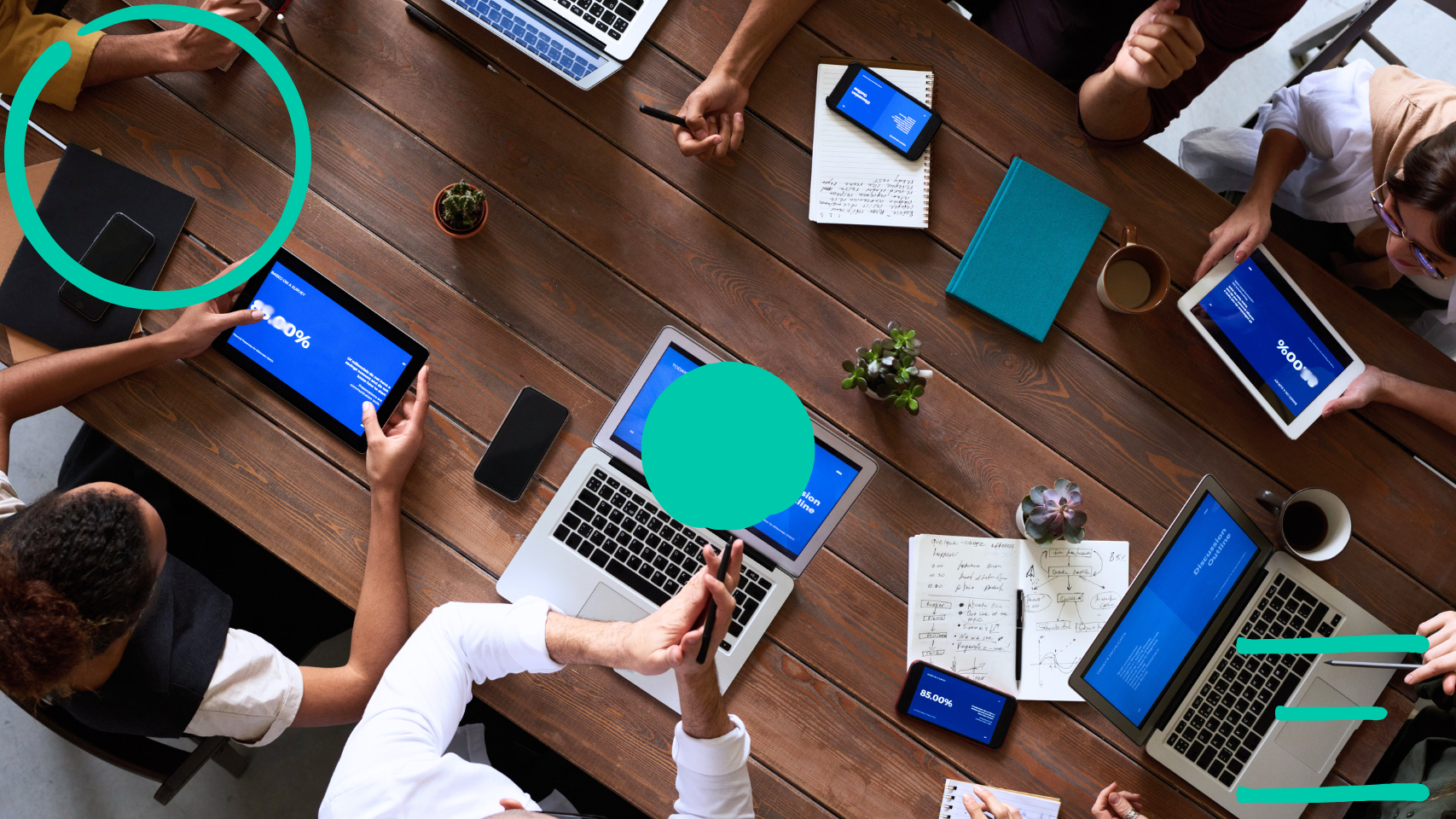 a group of people sitting around a table with laptops